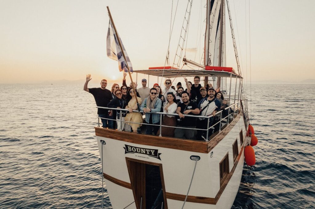 A group of people enjoy a sunset cruise on a sailboat named 'Bounty'.