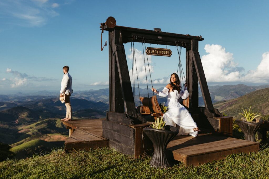 A couple captured in a scenic mountain setting with a swing, evoking romance.